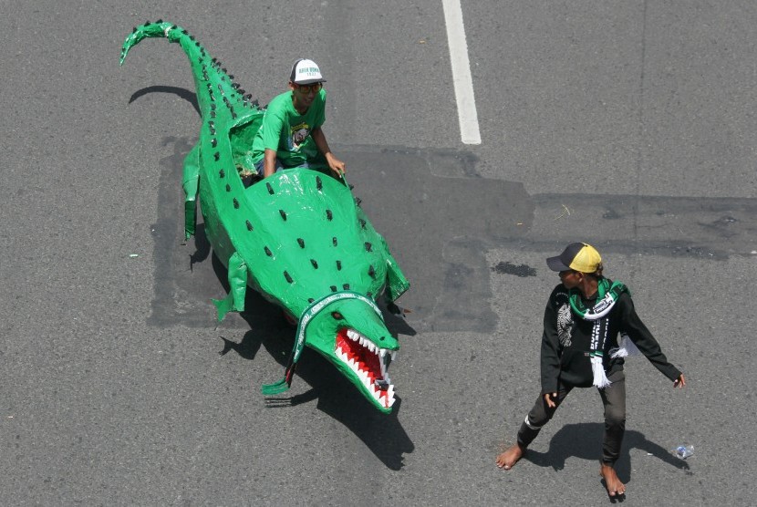 Seorang suporter Persebaya Surabaya mengendarai replika Buaya saat Parade Bela Persebaya di Surabaya. (ilustrasi) 