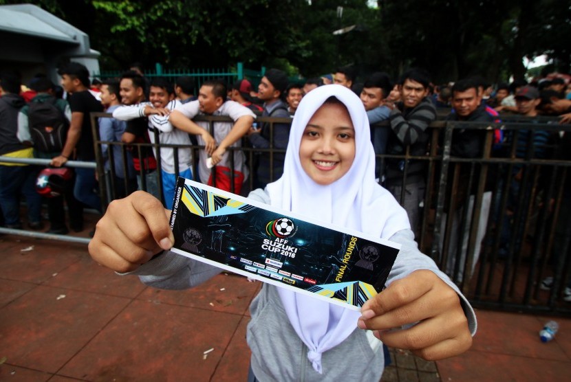 Seorang suporter sepak bola menunjukkan tiket semi final Piala AFF 2016 di kawasan Gelora Bung Karno (GBK), Jakarta, Jumat (2/12). Sebanyak 10 ribu tiket semi final Piala AFF 2016 khusus kateg