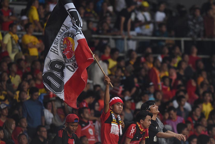 Seorang suporter tim Semen Padang mengibarkan bendera klubnya saat laga Final Piala Jenderal Sudirman di Stadion Utama Gelora Bung Karno, Jakarta, Ahad (24/1).