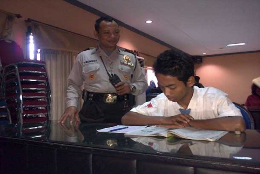   Seorang tahanan Polsek Kenjeran, Surabaya ikut serta dalam ujian nasional di aula Polres Pelabuhan Tanjung Perak,Surabaya, Senin (15/4).