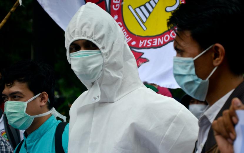 Seorang tenaga kesehatan rumah sakit Faisal memakai baju hazmat saat melakukan aksi unjuk rasa di Makassar, Sulawesi Selatan, Kamis (2/7/2020). Dalam aksinya mereka meminta pihak rumah sakit agar membayarkan intensif sepenuhnya kepada 157 tenaga kesehatan yang dirumahkan akibat dampak pandemi COVID-19.