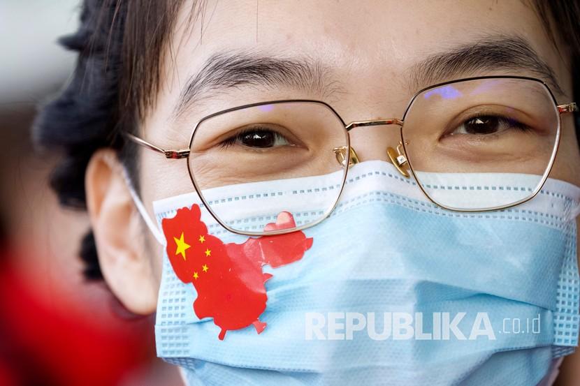 Seorang tenaga medis dari Provinsi Jilin memakai stiker berbentuk Negara China di wajahnya. Kasus kematian terakhir akibat Covid-19 di China terjadi pada dua tahun lalu. Ilustrasi.