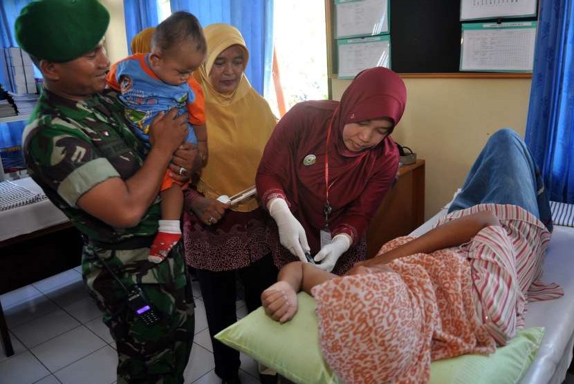 Seorang tenaga medis memasangkan alat kontrasepsi Implan KB atau Susuk pada seorang wanita saat berlangsung Pencanangan Kampung KB.