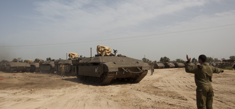 Seorang tentara Israel mengatur konvoi tanks Israel menuju perbatasan Jalur Gaza di Israel selatan. 