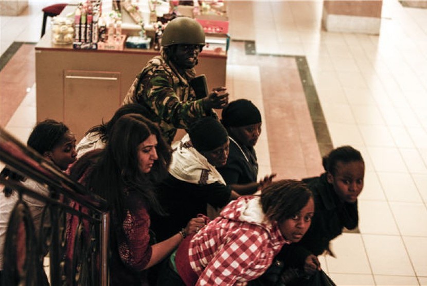 Seorang tentara mengevakuasi pengunjung mal Westgate di Nairobi, Kenya, yang diserang gerilyawan pada 21 September. 