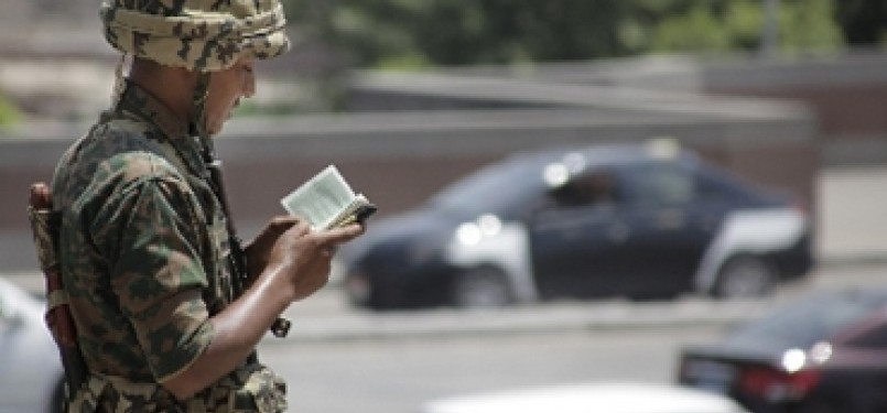 Seorang tentara Mesir membaca Al Quran, ketika bertugas menjaga masjid Al Azhar di Kairo, Mesir. (AP)