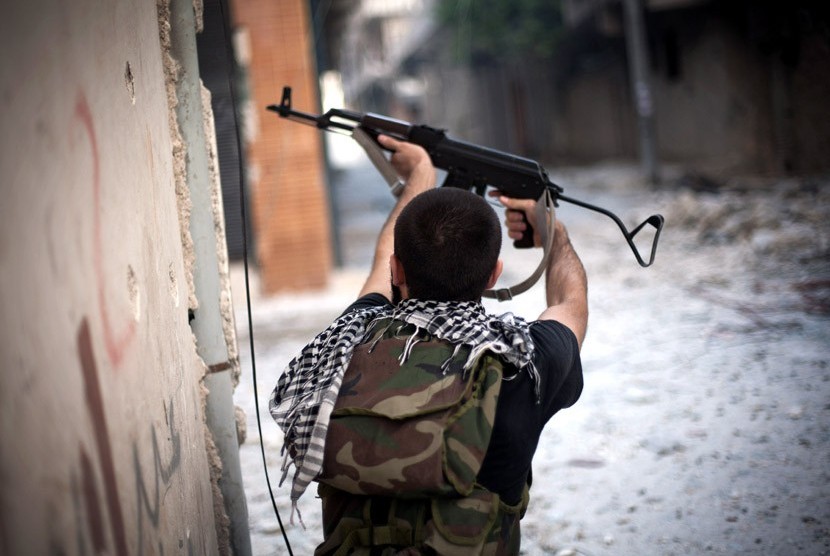  Seorang Tentara Pembebasan Suriah menembaki posisi tentara pemerintah Suriah di sebuah jalan di distrik Amariya Aleppo, Suriah, Senin (10/9).    (Manu Brabo/AP)