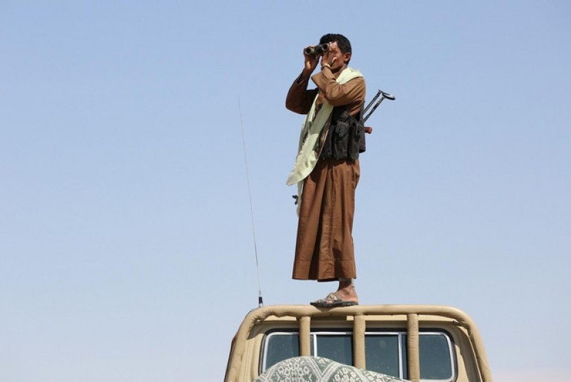 Seorang tentara suku di Yaman tengah mengamat pergerakan pasukan milisi Houthi.