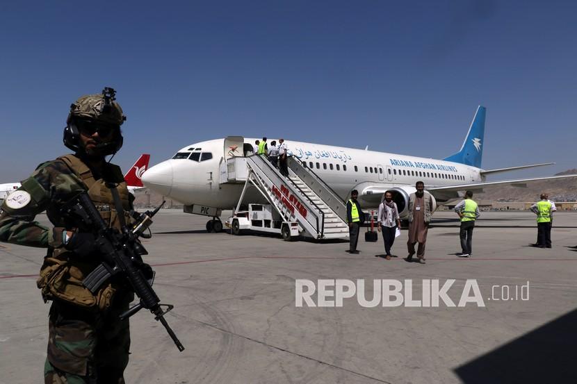  Seorang tentara Taliban berjaga-jaga ketika penumpang turun dari Kandahar, di Bandara Internasional Hamid Karzai di Kabul, Afghanistan, Ahad (5/9). Beberapa penerbangan domestik telah dilanjutkan di bandara Kabul, dengan maskapai penerbangan Ariana Afghan Airline yang dikelola pemerintah. ke tiga provinsi. 
