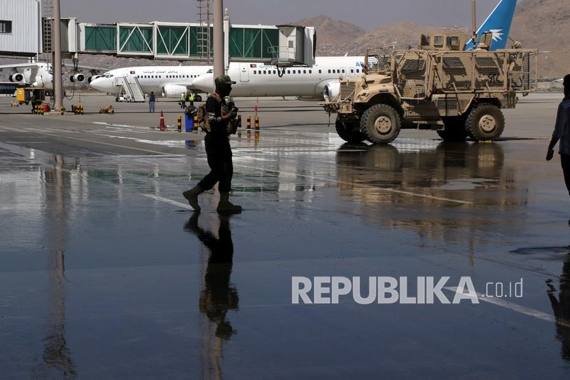  Seorang tentara Taliban berjalan di landasan dekat pesawat yang diparkir di Bandara Internasional Hamid Karzai di Kabul, Afghanistan. ilustrasi