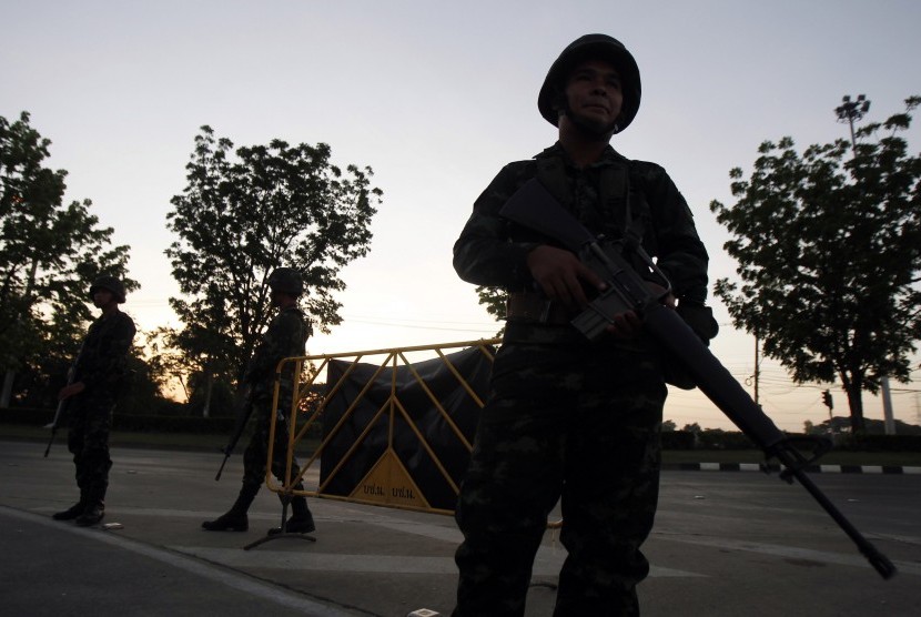 Seorang tentara terlihat berjaga-jaga di dekat 'checkpoint' kelompok pendukung pemerintahThailand di provinsi Nakhon Pathom, Bangkok, Kamis (22/5). Sebanyak 29 negara telah mengeluarkan 'travel warning' ke negara tersebut.