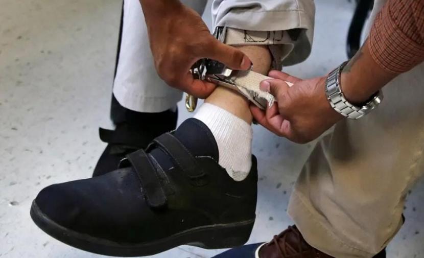 Seorang terapis memeriksa tali pergelangan kaki perangkat kejut siswa di Judge Rotenberg Center di Canton, Massachusetts, AS. 