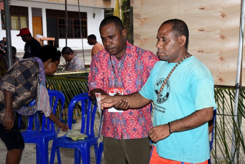 An Election Commission officer gave assistance to a disabled citizen to the voting chamber in the regional head election in Jayapura, Papua, Wednesday (Feb 15).