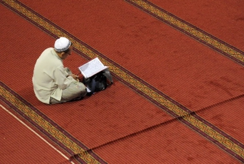 Seorang umat Muslim membaca Alquran usai melaksanakan shalat dhuha (ilustrasi).