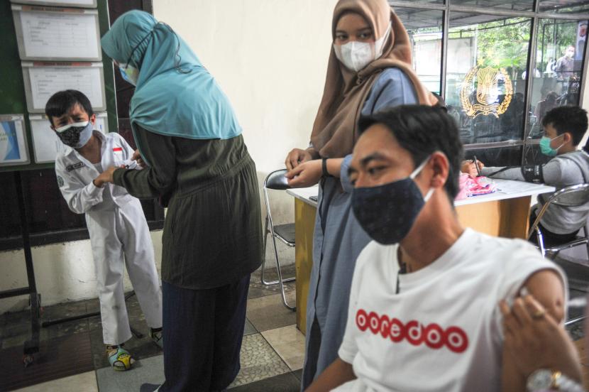 Seorang vaksinator memberikan vaksin COVID-19 dosis ketiga kepada warga di Polsek Sukasari, Bandung, Jawa Barat, Sabtu (5/3/2022). Pemerintah Kota Bandung tengah bersiap menuju perubahan dari pandemi COVID-19 ke endemi dengan salah satu cara yaitu melakukan percepatan vaksinasi yang hingga saat ini pencapaian vaksinasi dosis pertama sudah mencapai 112 persen, dosis kedua 100 persen dan dosis ketiga mencapai 15 persen.