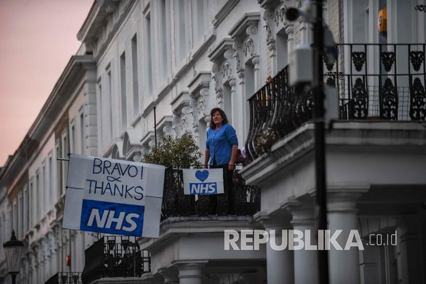Warga Inggris melakukan aksi mendukung NHS (Layanan Kesehatan Nasional). Dibayangi kekosongan stok, tenaga kesehatan Inggris akan diminta reuse APD.