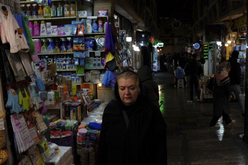 Seorang wanita berjalan melalui bazaar Tajrish di Teheran utara, Iran, Senin, 5 Desember 2022. Kebingungan atas status polisi agama Iran tumbuh ketika media pemerintah meragukan laporan bahwa pasukan tersebut telah ditutup.