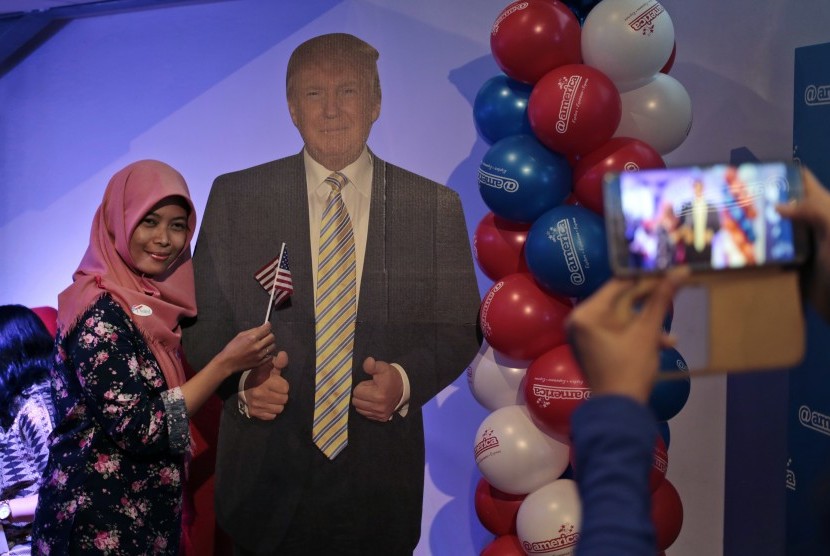 Seorang wanita berpose dengan Donald Trump dari karton. Masyarakat di seluruh dunia menyaksikan Pilpres AS tak ketinggalan di Indonesia.