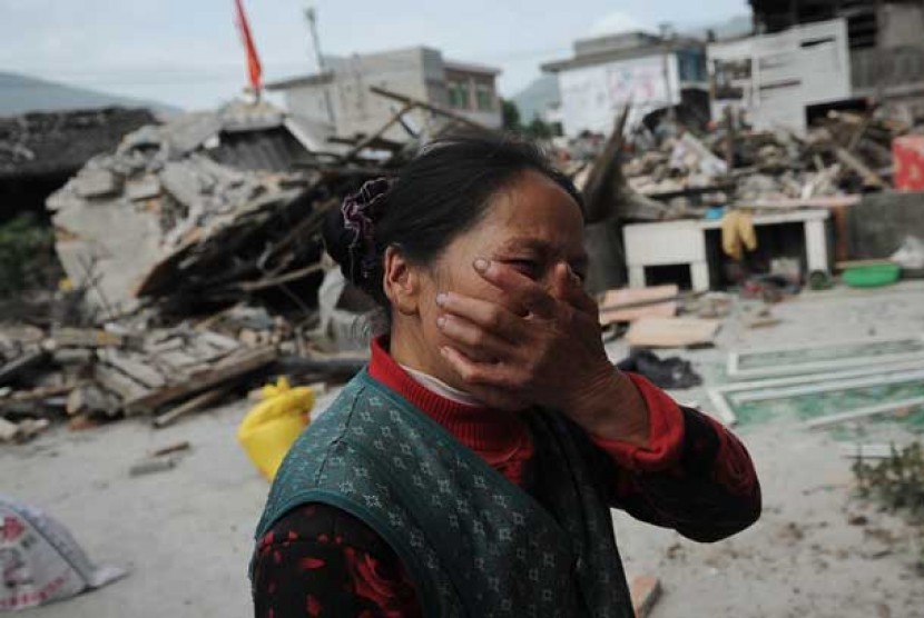 Seorang wanita desa menangis setelah rumahnya rusak akibat gempa bumi di Lushan provinsi Sichuan,Cina, Sabtu (20/4).
