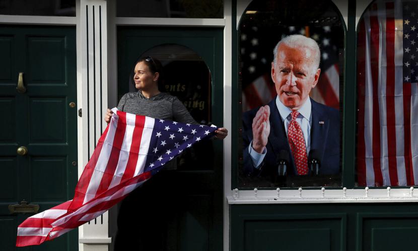 Seorang wanita di Ballina, Irlandia, memegang bendera Amerika sebagai bentuk antisipasi hasil pemilu AS, Sabtu (7/11). Moyang Joe Biden disebut berasal dari Irlandia. Kemenangan Biden disambut oleh publik di berbagai negara.