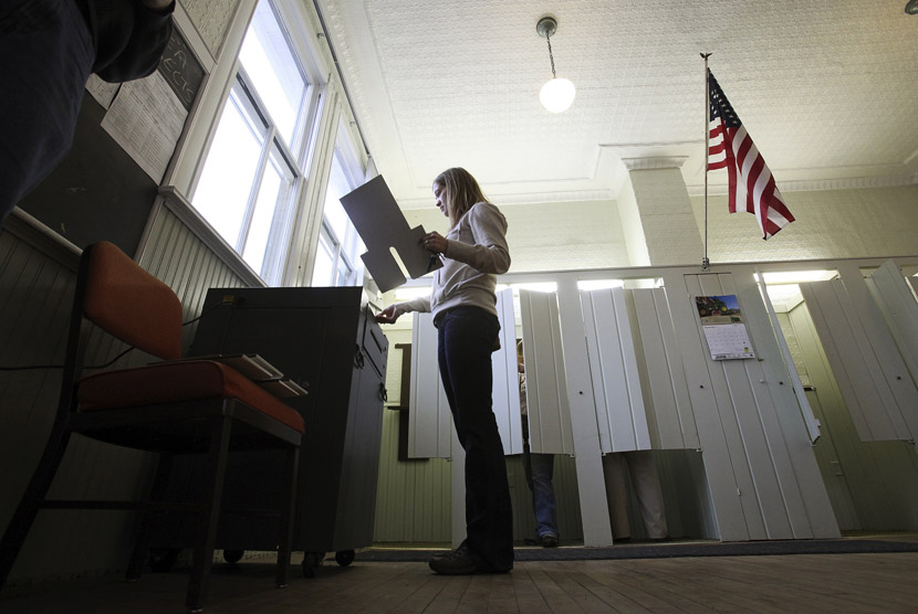  Seorang wanita memasukkan kertas suara ke dalam mesin penghitungan suara di Franconia, Minnesota, Rabu (6/11). (Reuters/Eric Miller)