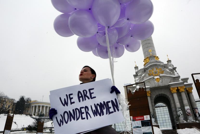 Seorang wanita memegang balon dan poster untuk memperingati Hari Perempuan Internasional di pusat kota Kiev, Ukraina, 8 Maret 2018. Perempuan di seluruh dunia akan menuntut kesetaraan upah, hak reproduksi, pendidikan, keadilan dan kebutuhan penting lainnya selama demonstrasi memperingati Hari Perempuan Internasional pada hari Jumat , 8 Maret 2024. 