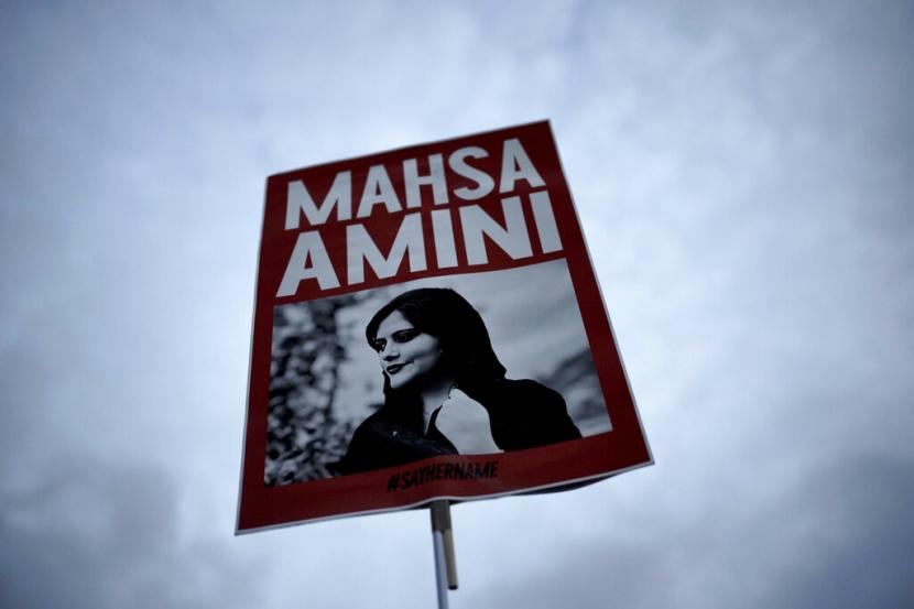 Seorang wanita memegang plakat bergambar Mahsa Amini Iran saat dia menghadiri protes terhadap kematiannya (ilustrasi). 