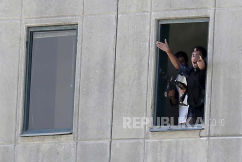 Seorang pria meminta pertolongan dari jendela Kompleks Parlemen Iran yang diserang  kelompok bersenjata di Teheran, Iran, Rabu (7/6)