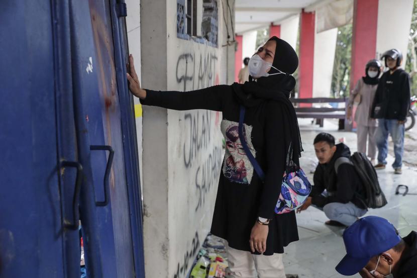 Seorang wanita menangis di depan pintu mengenang tragedi yang terjadi di Stadion Kanjuruhan, Malang, Jawa Timur.