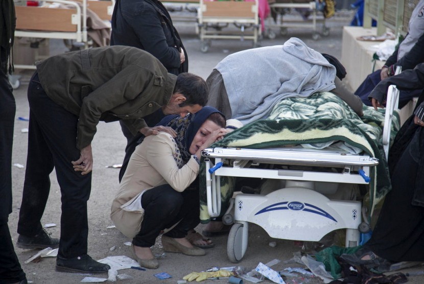 Seorang wanita menangisi jenazah korban gempa bumi di Kota Sarpol-e-Zahab di bagian barat Iran, Senin (13/11).