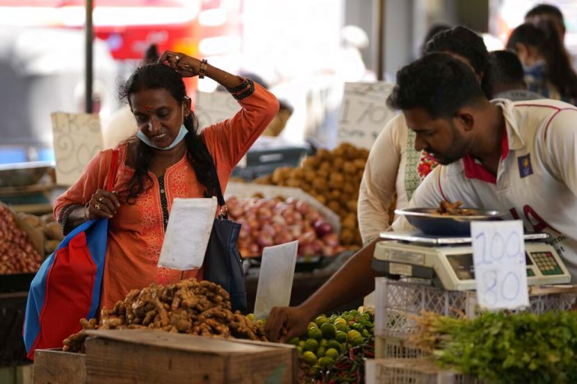 Seorang wanita menawar saat dia membeli sayuran di sebuah pasar di Kolombo, Sri Lanka, Jumat, 10 Juni 2022. Negara ini menghadapi krisis ekonomi terburuk dalam ingatan baru-baru ini.