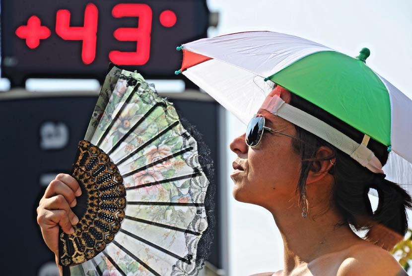 Seorang wanita mendinginkan diri untuk mengusir hawa panas 43 derajat celcius yang melanda Florence, Italia, Jumat (7/8). 