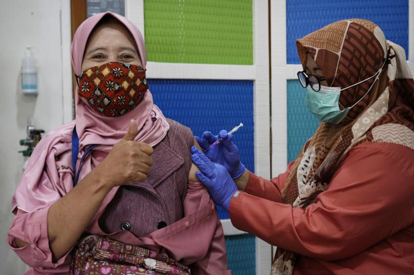 Seorang wanita menerima suntikan booster vaksin Pfizer COVID-19 di sebuah pusat kesehatan masyarakat di Jakarta, Indonesia, Senin, 17 Januari 2022.