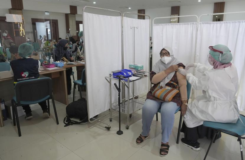 Seorang wanita menerima suntikan vaksin Pfizer COVID-19 selama kampanye vaksinasi dosis ketiga di Rumah Sakit Umum Daerah Tangerang Selatan di Tangerang, Indonesia, Rabu, 12 Januari 2022.