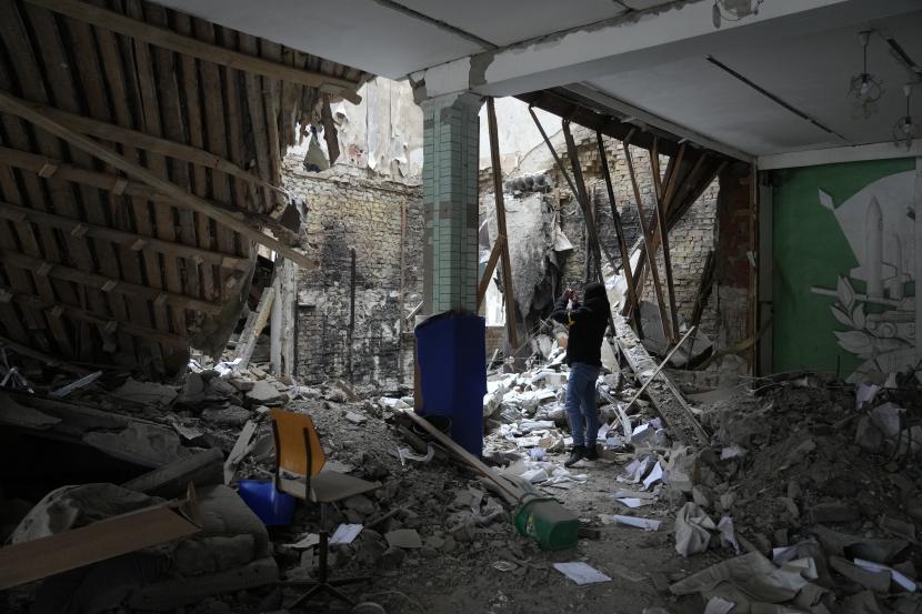 Seorang wanita mengambil foto bangunan akomodasi yang hancur di dekat pos pemeriksaan di Brovary, di luar Kyiv, Ukraina, Selasa, 1 Maret 2022. Bank Dunia dan Dana Moneter Internasional (IMF) pada Selasa (1/3/2022) mengatakan mereka berlomba untuk memberikan miliaran dolar dana tambahan ke Ukraina dalam beberapa minggu mendatang.