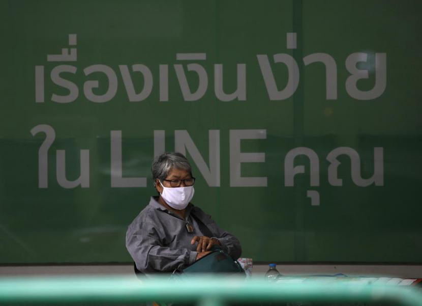  Seorang wanita mengenakan masker duduk di depan bank di kawasan bisnis Bangkok, Thailand, 21 April 2021. Pemerintah Thailand umumkan Bangkok dan beberapa provinsi lain harus melakukan pengawasan maksimum dan protokol kesehatan ketat menyusul meningkatnya kasus Covid-19. 