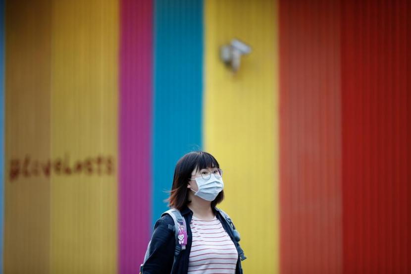 Seorang wanita mengenakan masker sebagai upaya pencegahan dari virus Covid-19. China mengembangkan vaksin Covid-19 lewat unit CNBG yang berkedudukan di Beijing.