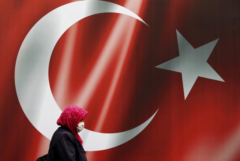 Komentar Minoritas Muslim, Menlu Turki Buat Yunani Marah. Foto: Seorang wanita mengenakan topeng berhias bendera Turki untuk membantu mengekang penyebaran virus corona di dekat konsulat Prancis di Istanbul, Rabu, 28 Oktober 2020.