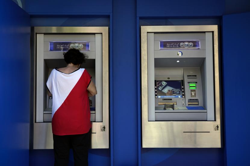 Seorang wanita menggunakan ATM di Beirut, Lebanon (ilustrasi). Pemerintah Lebanon tidak akan dapat membayar gaji pegawai negeri sipil pada akhir Juni 2023.