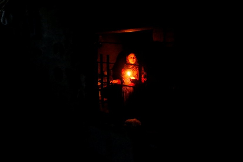 Israel Cegah Pasokan Listrik untuk Warga Jalur Gaza. Seorang wanita menggunakan lilin saat beraktivitas di dapur rumahnya di Beit Lahiya, di utara Jalur Gaza akibat krisis listrik. Gambar diambil pada 11 Januari 2017.