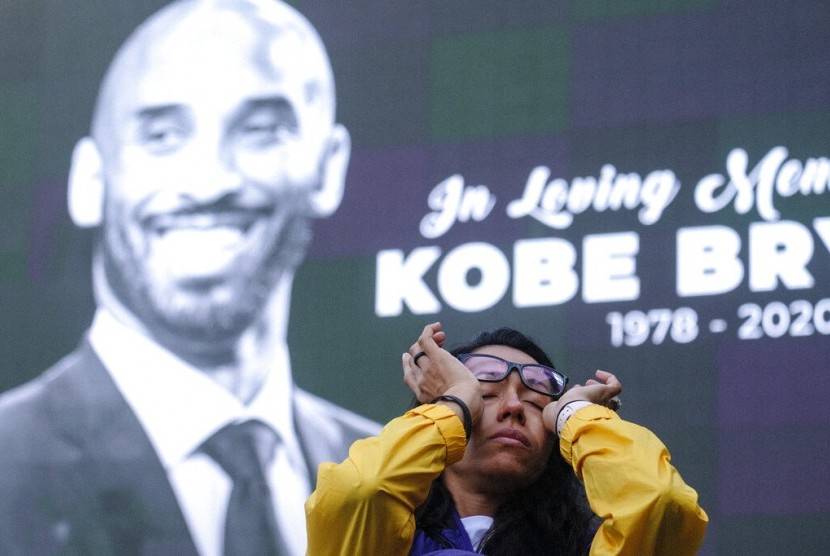Seorang wanita menghapus air matanya saat berkumpul di Staples Center Los Angeles, Senin (27/1) waktu AS, untuk mengenang kepergian Kobe Bryant.
