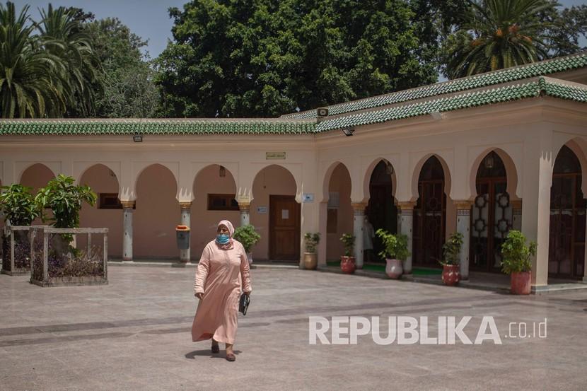 Seorang wanita meninggalkan masjid sambil mengenakan masker di masjid di Rabat, Maroko, Rabu (15/7/2020). Raja Maroko Serukan Warga Sholat Istisqa