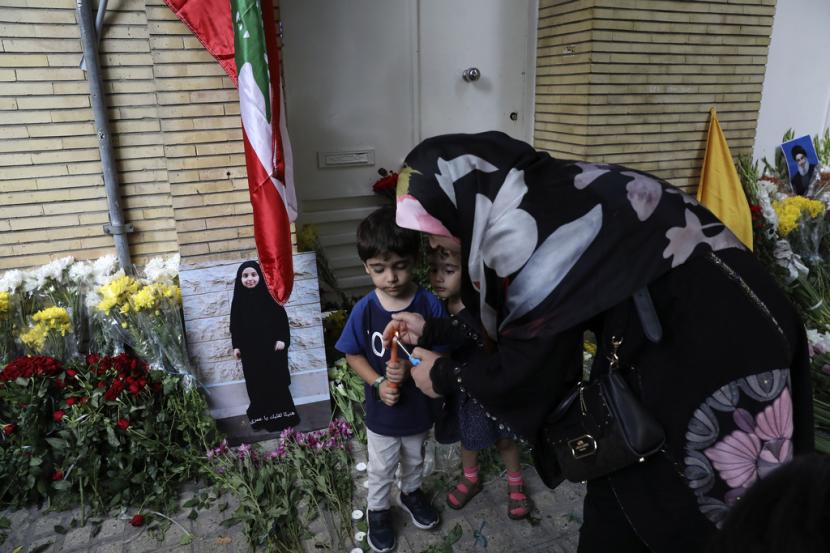 Seorang wanita menyalakan lilin di depan Kedutaan Besar Lebanon di Teheran, Iran, Rabu, 18 September 2024. 