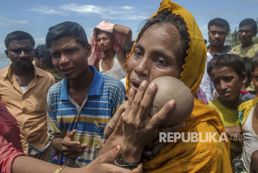 Seorang wanita Muslim Rohingya Hanida Begum, yang menyeberang dari Myanmar ke Bangladesh, sangat sedih saat memegang anak laki-lakinya, Abdul Masood yang meninggal saat kapal yang mereka tumpangi terbalik sebelum mencapai pantai Teluk Benggala, di Shah Porir Dwip, Bangladesh, Kamis (14/9).