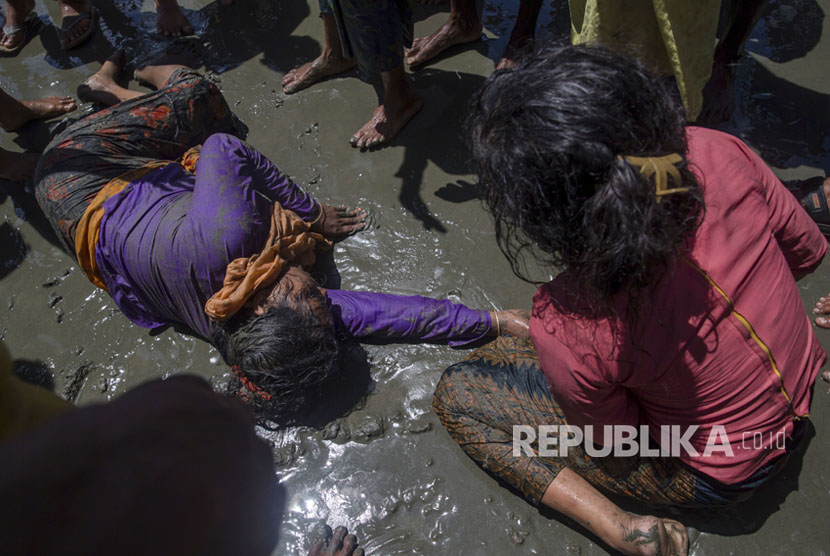 Seorang wanita Muslim Rohingya, yang menyeberang dari Myanmar ke Bangladesh, terbaring tak sadarkan diri di tepi Teluk Bangal setelah kapal yang dia tumpangi terbalik di Shah Porir Dwip, Bangladesh (Ilustrasi)