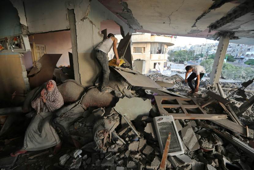  Seorang wanita Palestina duduk di dalam rumahnya yang hancur akibat serangan udara Israel, di Kota Gaza, Kamis (17/7).  (Reuters/Finbarr O'Reilly)