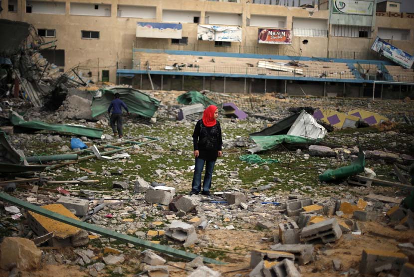  Seorang wanita Palestina menyaksikan reruntuhan stadion sepak bola, yang hancur akibat serangan udara Israel selama konflik delapan hari di Kota Gaza,Selasa (4/12). (Reuters/Suhaib Salem)