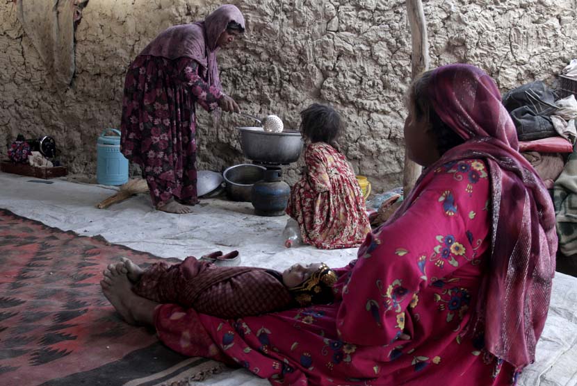 Seorang wanita pengungsi Afghanistan memasak makanan untuk berbuka puasa di Kabul, Afghanistan, Senin (22/7). (AP/Rahmat Gul)