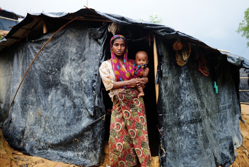 Seorang wanita pengungsi Rohingya bersama anaknya berdiri di Kamp Pengungsian Ukhia, Cox Bazar, Bangladesh, Kamis (28/9).