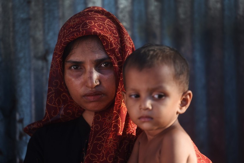 Seorang wanita pengungsi Rohingya menggendong anaknya di Kamp Pengungsian Kutupalong, Cox Bazar, Bangladesh, Minggu (1/10).